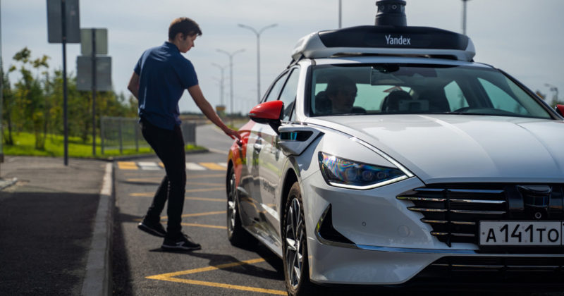 мужчина садится в беспилотный автомобиль яндекс такси